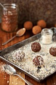 Date energy balls being rolled in desiccated coconut
