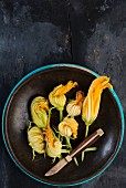 Courgette flowers in a brown bowl