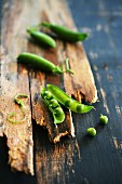 Pea pods on a rustic wooden surface