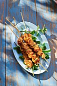 Chicken kebabs with mint on a table outside