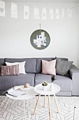 Grey sofa and white tray table in Scandinavian-style living room