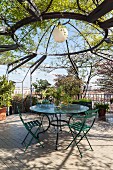 Seating area under climber-covered pagoda on roof terrace