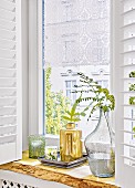 A romantic lace curtain in a window with decorative plants on the window sill