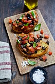 Grilled bread topped with tomatoes and olives