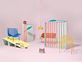 An arrangement of retro-style garden furniture and accessories in a pastel coloured studio