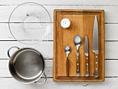 Kitchen utensils: a pot, a glass bowl, a egg piercer and cutlery