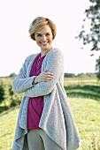 A young woman wearing a top and a fluffy cardigan