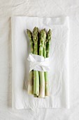 A bunch of green asparagus on a white cloth