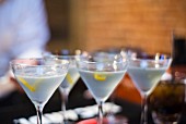 Four martinis with lavender and lemon peel in a bar