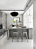 Designer bar stools at concrete counter in kitchen with rustic grey cupboards