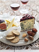 A cheeseboard with crackers, figs, nuts and dates