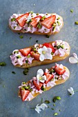 Eclairs with strawberries, cream and pistachios