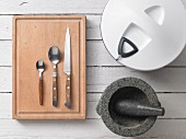 Assorted kitchen utensils: cutlery, a salad spinner and a pestle and mortar