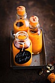 Vegan pumpkin shots with chilli flakes in small glass bottles