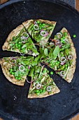 A superfood pizza with red-veined dock, peas, asparagus and pesto