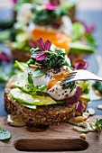 Bread topped with avocado, a poached egg, and green cabbage tapenade (Superfood)
