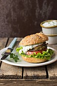 A burger with fried aubergine, tzatziki, tomato and lettuce