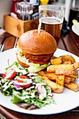 A vegan burger with chips and salad in a restaurant