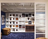 Shoes and accessories on white, custom shelving in masculine sales room