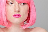 Junge Frau mit pinkfarbener Perücke und Lippenstift
