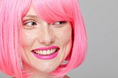 Junge Frau mit pinkfarbener Perücke und Lippenstift