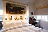 Antique bureau and bed against partition wall in bedroom