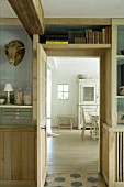 Fitted shelves around kitchen door and view into dining area