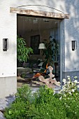 View from garden into living room through large floor-to-ceiling window