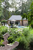 Summer house and pool in summery garden with mature trees