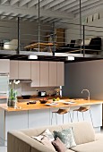 Kitchen below living room on mezzanine in open-plan interior