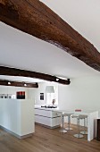 Rustic beams above counter in white designer kitchen
