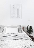 Sketches of New York above bed with pale bed linen