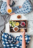 Breakfast in bed with fruit, a cinnamon swirl, coffee and tea