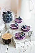 Mini blueberry cheesecakes on a white chopping board