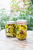 Picked lemons in two jars on a wooden table