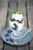 An ice cream with blueberries and mint leaves