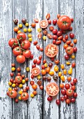 Various types of tomatoes on wooden background