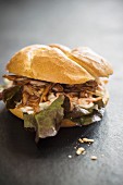 A pulled pork sandwich with oak leaf lettuce