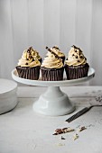 Chocolate cupcakes with white chocolate icing on a cake stand