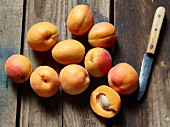 Fresh apricots with a kitchen knife on a wooden surface