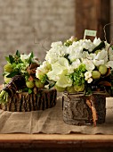 White and green flower arrangements on slices of tree trunks