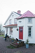 Woman decorating a table for Christmas outside wooden house