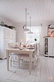Set dining table in white, cottage-style kitchen-dining room