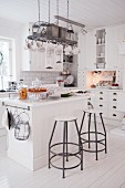 Island counter and bar stools in white country-house kitchen