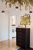 Christmas tree with fairy lights on top of chest of drawers