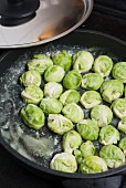 Brussels sprouts being fried in butter