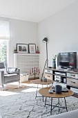 Delicate coffee tables with live-edge tops in front of TV on sideboard