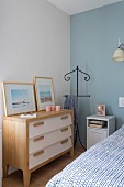 Valet stand between chest of drawers and bedside cabinet in corner of bedroom