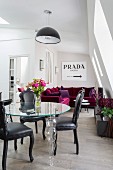 Glass designer table, leather chairs and velvet sofa in attic interior