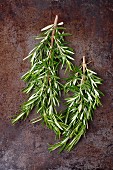 Fresh sprigs of rosemary on a metal surface